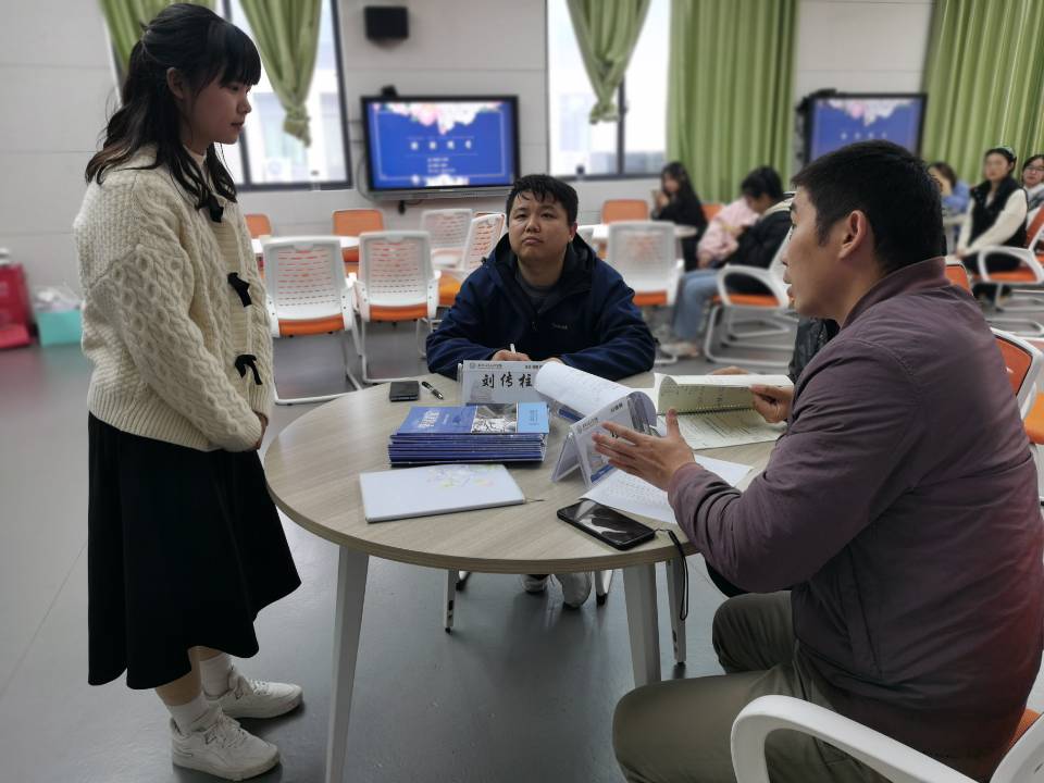图为评委老师对参赛选手笔记进行点评.jpg