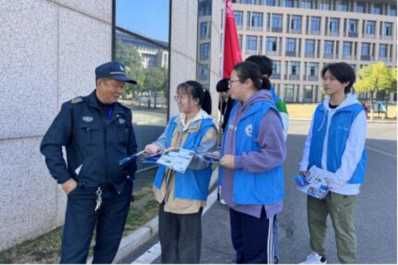 图为志愿者向保安叔叔分发传单.jpg