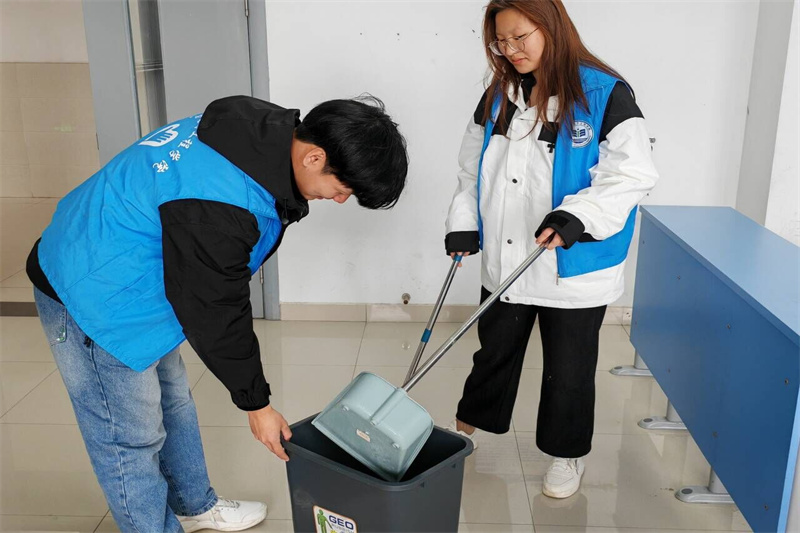 图为电气2302班级志愿者清扫教室地板.jpg