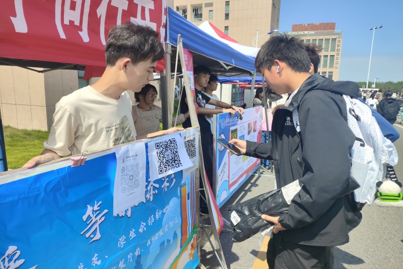 图为工作人员向新生介绍报名流程.jpg