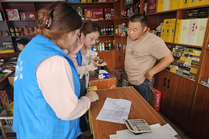 图为成员在东临溪村向村民发放问卷.jpg