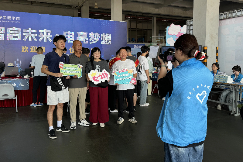 图为志愿者为新生及家人拍下合照.jpg
