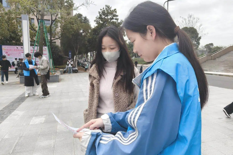 图为志愿者展示宣传册.jpg