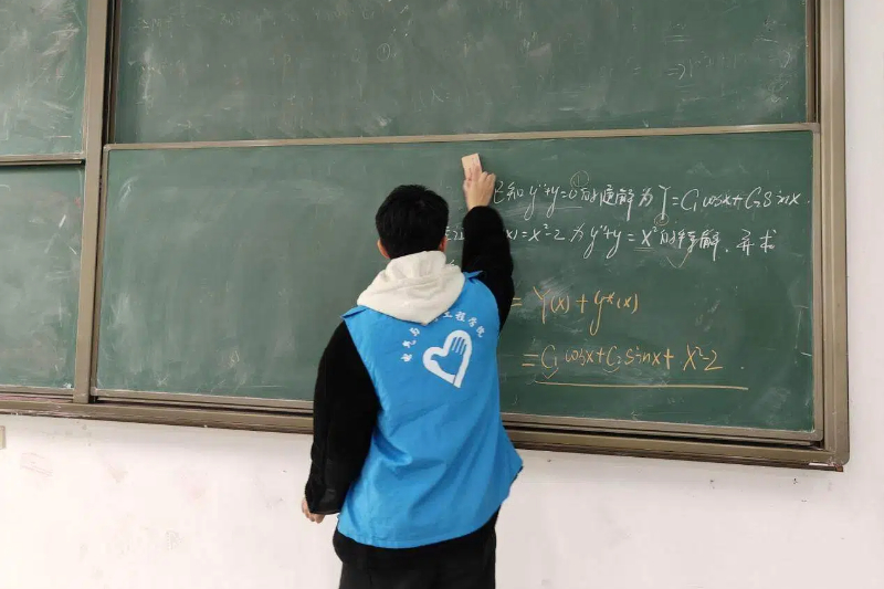 图为志愿者在教室打扫卫生.jpg