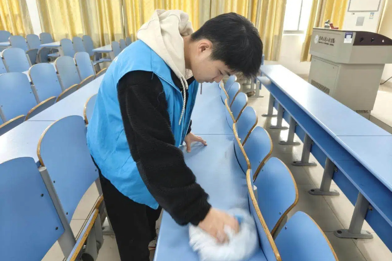 图为志愿者在清除桌子上的涂鸦.jpg