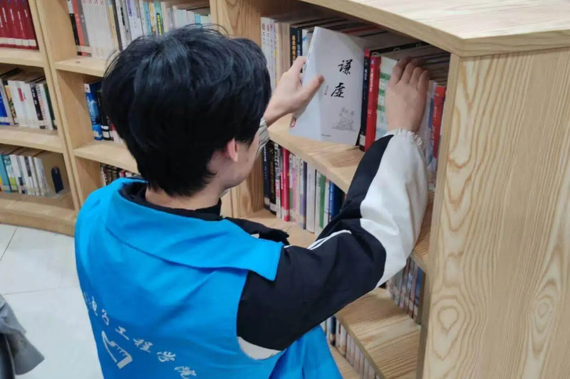 图为志愿者整理书籍.jpg