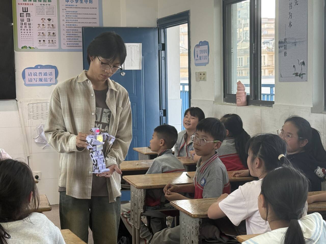 图为党员志愿者近距离为小学生讲解机器人.jpg