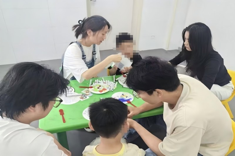 图为志愿者陪伴孩子绘画.jpg