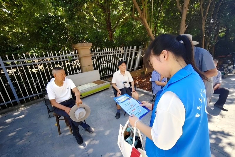 图为志愿者向附近居民宣传反诈知识.jpg