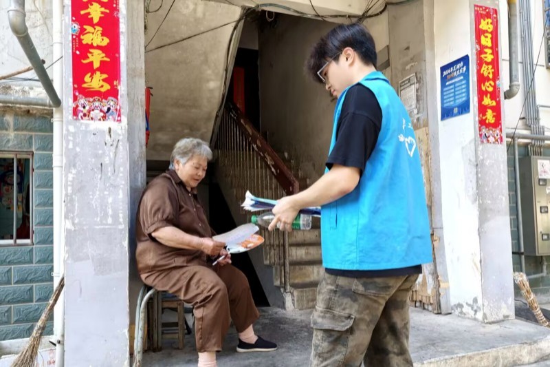 图为志愿者向社区居民宣传防诈骗.jpg
