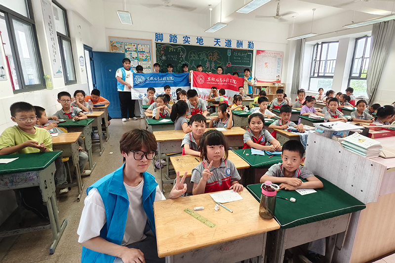 图为实践队员与小学生合照.png