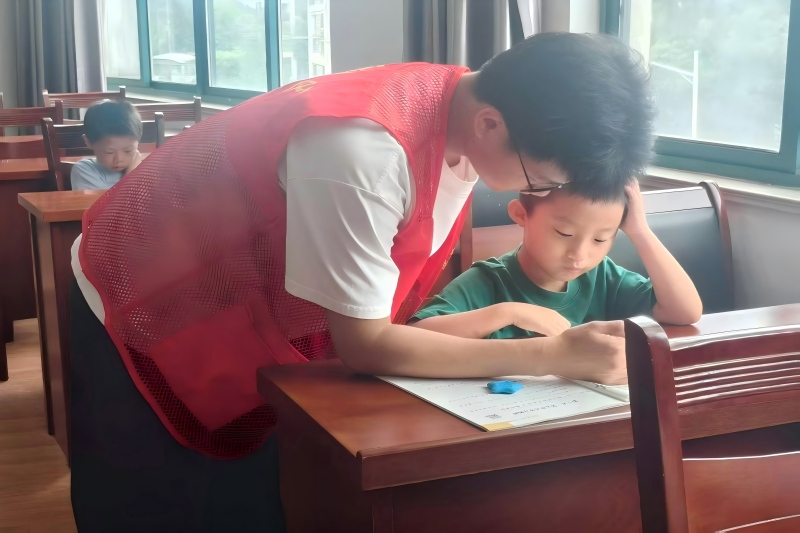 图为志愿者辅导小朋友作业.jpg