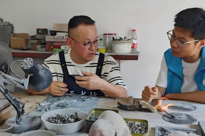 图为团队队员与徽州石雕非遗传承人詹华平开展访谈交流.jpg
