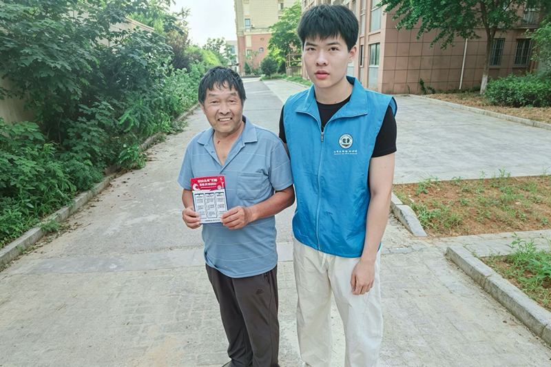 图为实践队成员为居民讲解台风天用电知识.png