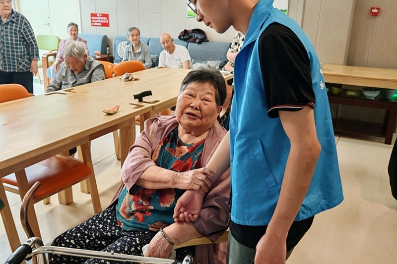 图为志愿者陪伴老人交流谈心.png