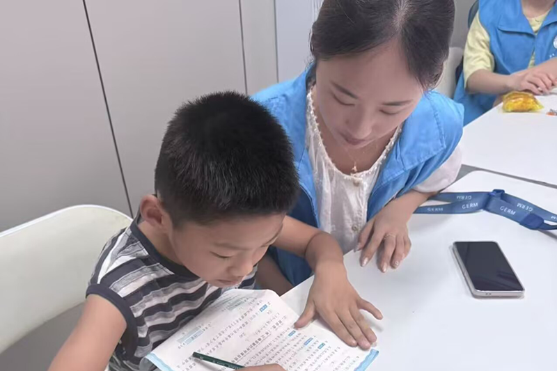图为志愿者为社区儿童讲述红色故事.png
