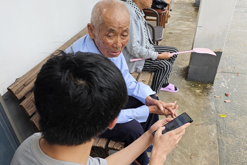 图为实践团成员为老人宣传反诈知识.jpg