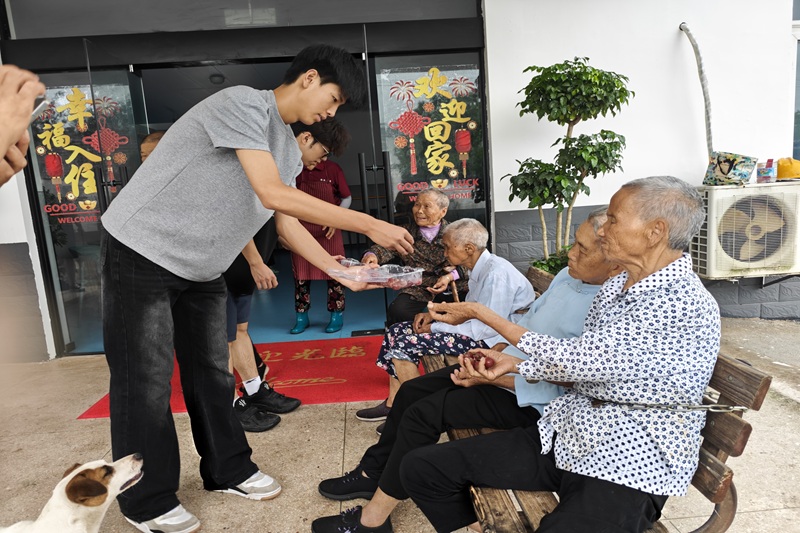 图为实践团成员向老人分发水果.jpg