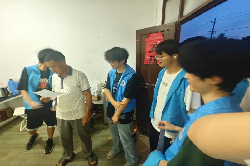 图为志愿者陪同村民阅读调研材料，倾听村民心声.jpg
