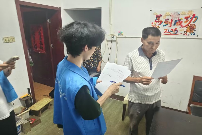 图为实践队员向村民细致讲解调查问卷内容.jpg