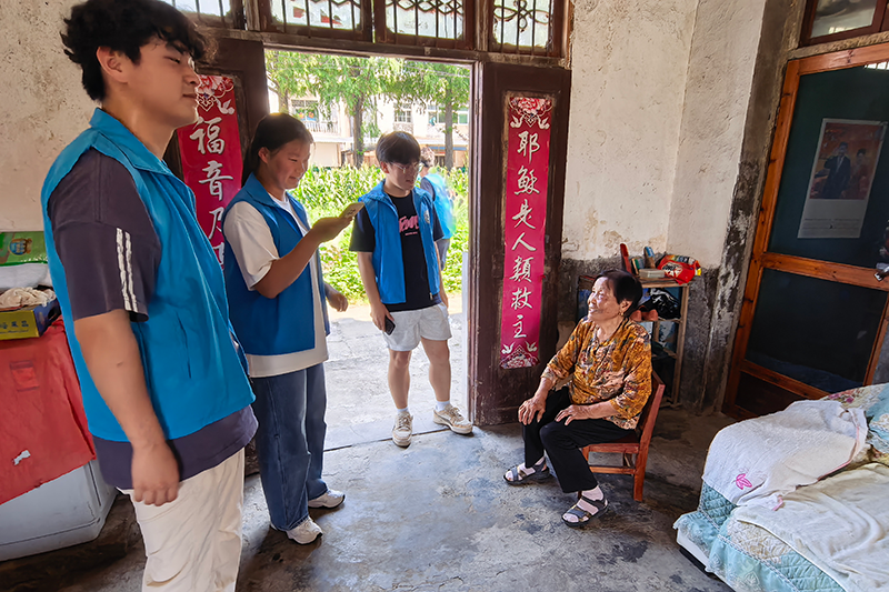 图为队员为村民讲解安全用电与节能科普知识.png