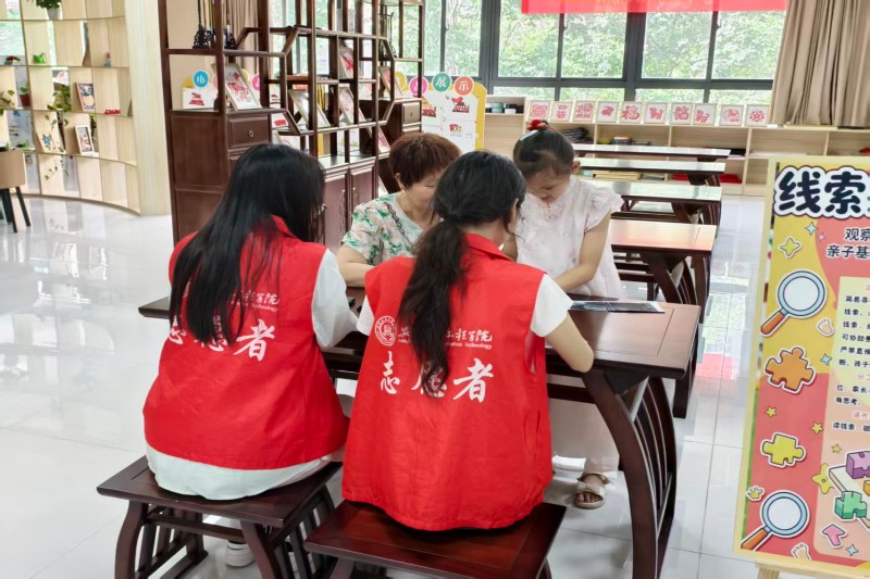 图为志愿者协助亲子家庭完成互动游戏.jpg