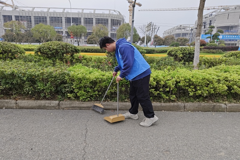 图为志愿者清扫绿化带.jpg