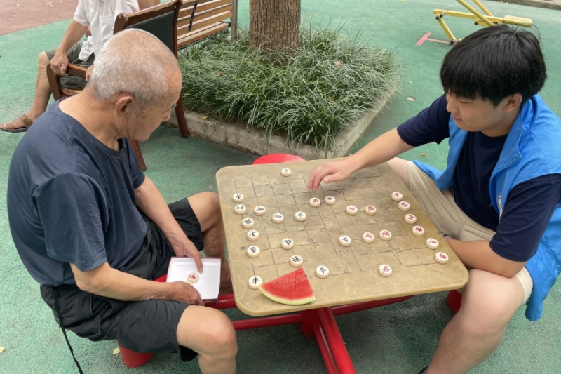 图为志愿者与老人下棋照片.jpg