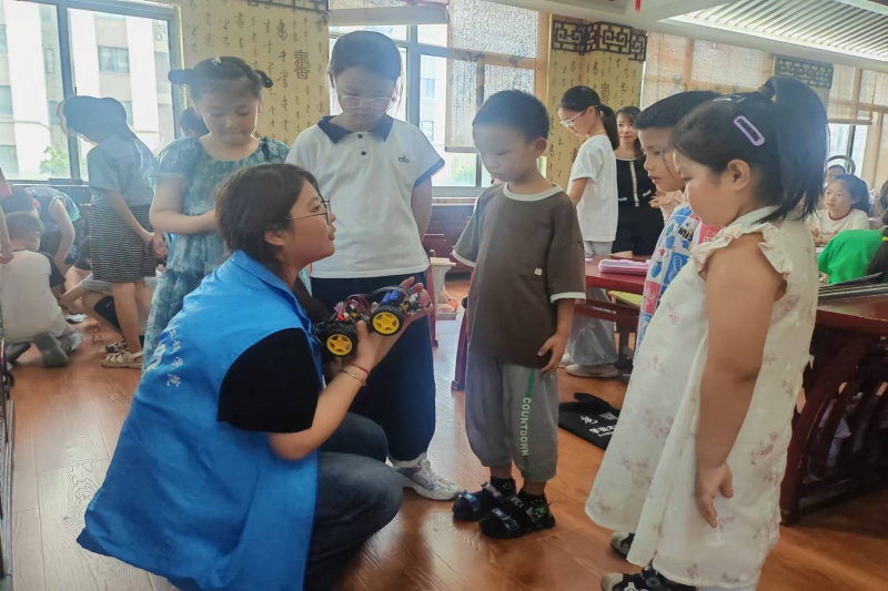 图为科普益课实践团成员为小朋友讲解智能车原理.jpg